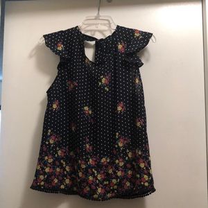 Sleeveless floral patterned navy blue shirt with white polka dots